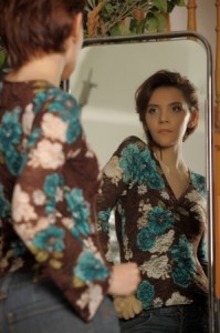 鏡の前で姿勢をチェックする女性のイメージ