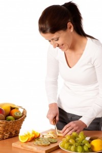 包丁とまな板で料理をする女性のイメージ